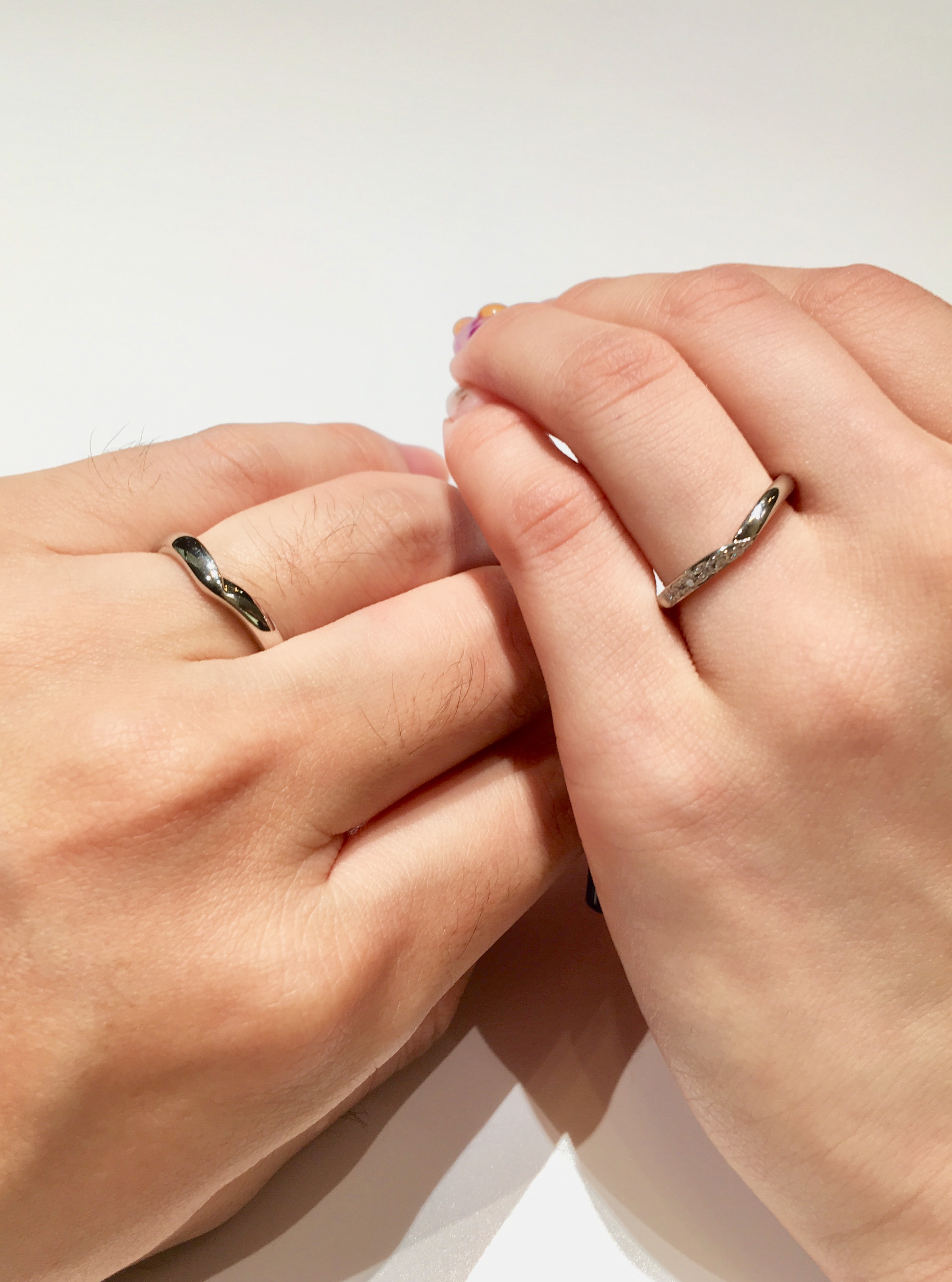 V字の結婚指輪をつけた二人の手元の画像